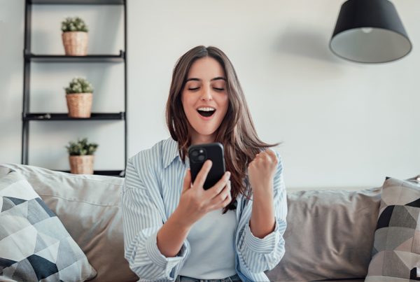Mujer celebrando la función suscripción a tus boletos de TuLotero