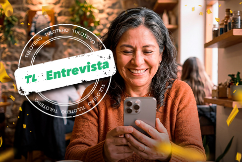 Mujer sonriente mirando su celular en una imagen sobre la ganadora de Tris.